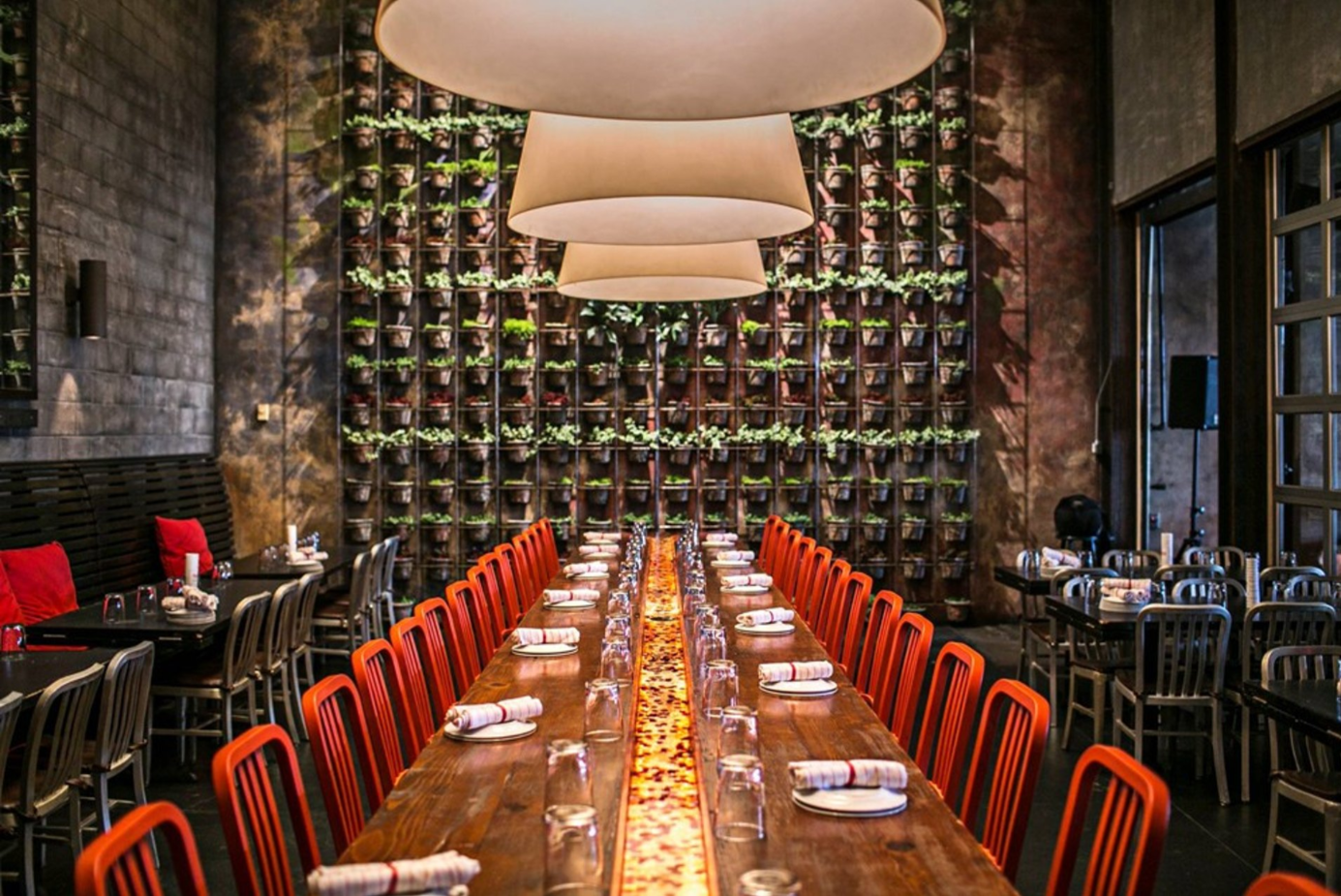 Communal table with glowing inlay beneath the green wall